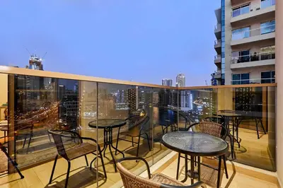 a balcony with tables and chairs and a view of a city at 2BHK Canal View Stay-Business Bay in Dubai
