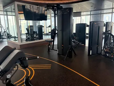 a gym with several treadmills and a flat screen tv at Stunning Burj Khalifa View 3BR Imperial Avenue in Dubai