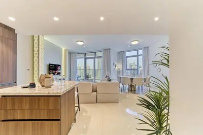 a kitchen and living room with a couch and a table at Stunning Burj Khalifa View 3BR Imperial Avenue in Dubai