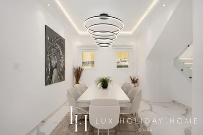 a white dining room with a white table and chairs at LUX The Serene Springs Villa 2 in Dubai
