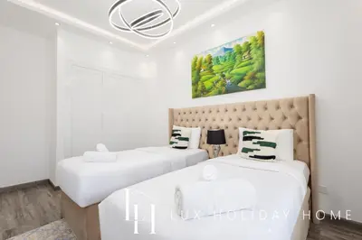 two beds in a bedroom with white walls at LUX The Serene Springs Villa 2 in Dubai