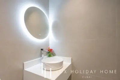 a bathroom with a white sink and a mirror at LUX The Serene Springs Villa 2 in Dubai