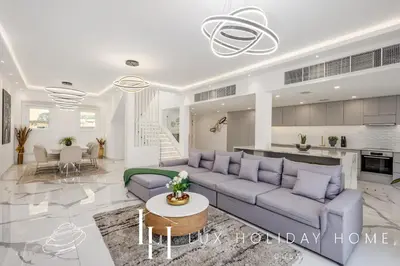 a living room with a couch and a table at LUX The Serene Springs Villa 2 in Dubai