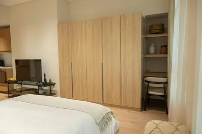 a bedroom with a bed and a cabinet with a television at Stylish cozy studio in the heart of Business Bay in Sabkhah