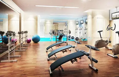 a gym with a lot of treadmills and machines at Stylish cozy studio in the heart of Business Bay in Sabkhah