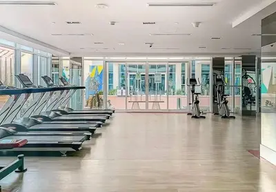 a gym with rows of treadmills and exercise bikes at Cozy 1BR Near Metro in Starz Tower 2 in Dubai
