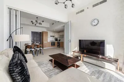 a living room with a couch and a tv at Cozy 1BR Near Metro in Starz Tower 2 in Dubai
