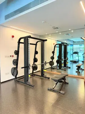 a gym with several tread machines and a mirror at Cozy & Stylish 1BR in Wilton Terraces in Dubai