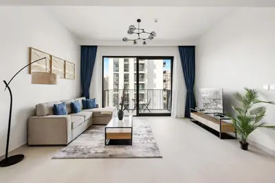 a living room with a couch and a table at Elegant 2BR Close to Park in Park Horizon in Dubai