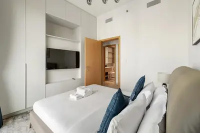 a living room with a white couch and a tv at Elegant 2BR Close to Park in Park Horizon in Dubai