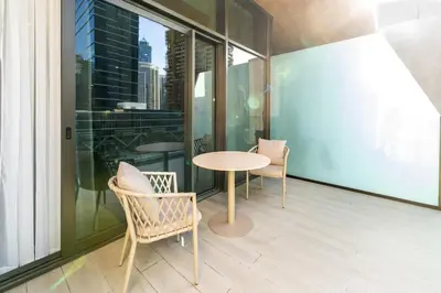 a table and chairs on the balcony of a building at Escape24 Brand New 2BR with Canal Views near Burj Khalifa in Dubai