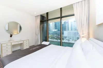 a bedroom with a large bed with a large window at Escape24 Brand New 2BR with Canal Views near Burj Khalifa in Dubai