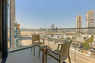 a balcony with two chairs and a view of a city at Stylish 1BR in Great Community in Dubai