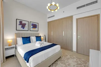 a bedroom with a large bed with blue pillows at Stylish 1BR in Great Community in Dubai