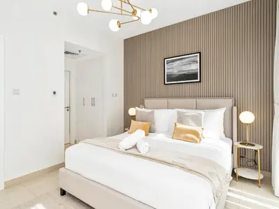 a bedroom with a large white bed with two pillows at Kensington - 1BR Fountain-view Flat Downtown in Dubai