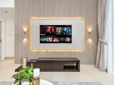 a living room with a flat screen tv on a wall at Kensington - 1BR Fountain-view Flat Downtown in Dubai