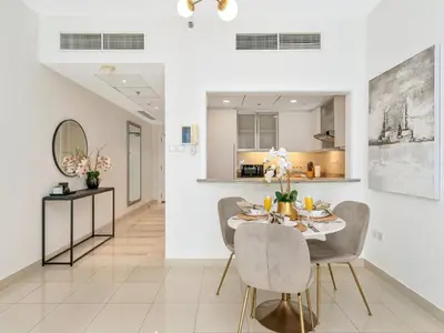 a dining room with a table and chairs at Kensington - 1BR Fountain-view Flat Downtown in Dubai