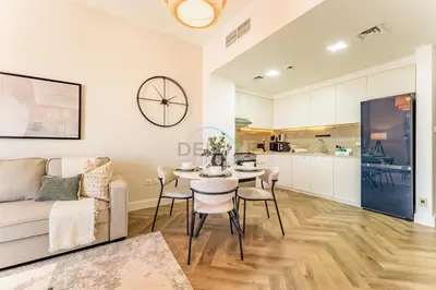 a living room with a table and a couch at Just Steps from the Community Center with Top-Tier Amenities, Minutes Walk to the Park, Hayat Boulevard 2A, Town Square by Deluxe Holiday Homes in Dubai