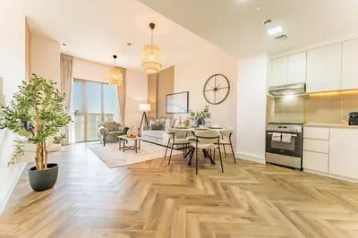 a kitchen and living room with a table and chairs at Just Steps from the Community Center with Top-Tier Amenities, Minutes Walk to the Park, Hayat Boulevard 2A, Town Square by Deluxe Holiday Homes in Dubai