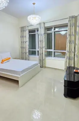 a bedroom with a bed and a large window at Large 2 BHK Apartment Next to DMCC Metro Station in Dubai