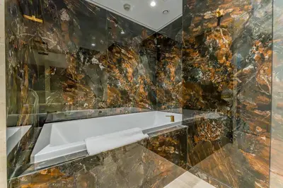 a bathroom with a marble wall with a mirror at Community View, Near Dubai Creek Harbour Marina Walk - Summer at Creek Beach Building 2 by Deluxe Holiday Homes in Dubai