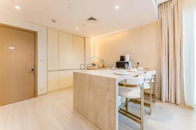 a kitchen with a counter and a bar with stools at Community View, Near Dubai Creek Harbour Marina Walk - Summer at Creek Beach Building 2 by Deluxe Holiday Homes in Dubai