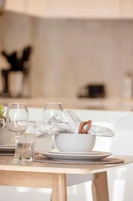 a table with a bowl and two glasses on it at Chic 2BR Haven in Prime Location in Gardenia Living in Dubai