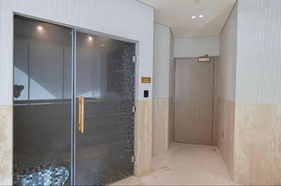 a glass shower with a door in a room at Vogue JVC Binghatti Phantom near Circle Mall, One Bedroom Apartment with Large Balcony and City View, Access to all Amenities in Dubai