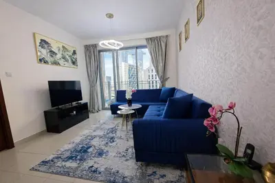 a living room with a blue couch and a tv at 1BR with Burj Khalifa Modern Comfort in Dubai