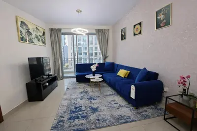 a living room with a blue couch and a tv at 1BR with Burj Khalifa Modern Comfort in Dubai
