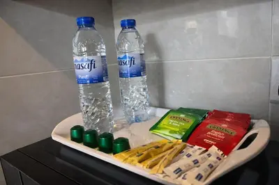 a tray with two bottles of water and snacks at 1BR with Burj Khalifa Modern Comfort in Dubai