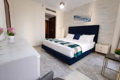 a bedroom with a king sized bed and a desk at 1BR with Burj Khalifa Modern Comfort in Dubai