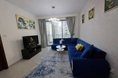 a living room with a blue couch and a tv at 1BR with Burj Khalifa Modern Comfort in Dubai