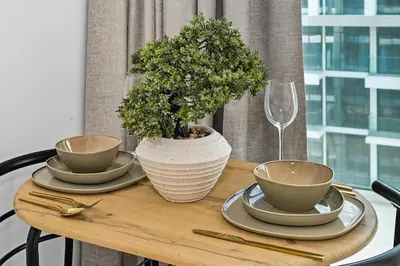 a wooden table with three bowls and a plant on it at Zafir Studio in Dubai by beBalmy in Dubai