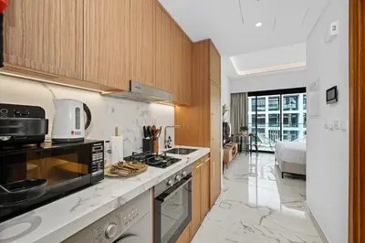 a kitchen with a stove top oven next to a bed at Zafir Studio in Dubai by beBalmy in Dubai