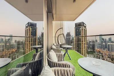 a balcony with tables and chairs and a view of a city at Keylid Stunning3BR and Maid connected to Dubai Mall in Dubai
