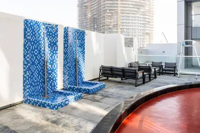 a lobby with a pool and blue tile walls at Luxury Dubai Studio with Private Pool & Desert Views in Dubai