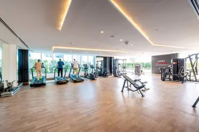 a gym with treadmills and people exercising in it at Luxury Dubai Studio with Private Pool & Desert Views in Dubai