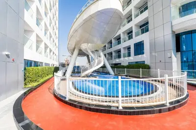 a spiral staircase leading to a building with a pool at Luxury Dubai Studio with Private Pool & Desert Views in Dubai