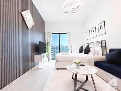 a living room with a bed and a table at Dubai aziIzi in Dubai