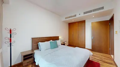 a bedroom with a large white bed with blue pillows at 2 bedroom JLT with park view in Dubai