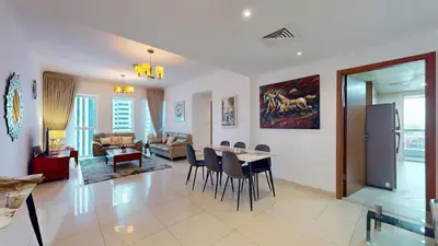 a living room with a table and chairs and a couch at 2 bedroom JLT with park view in Dubai