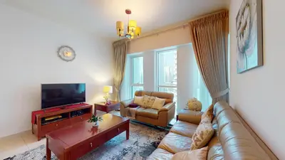 a living room with a couch and a tv at 2 bedroom JLT with park view in Dubai