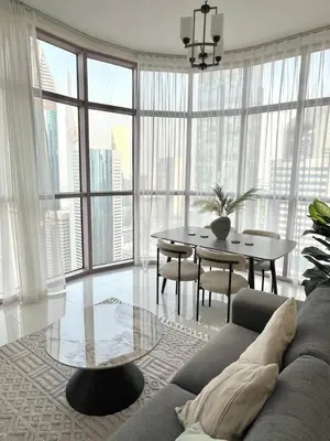 a living room with a couch and a table and chairs at 1BR Amazing Burj And Dubai View in Dubai