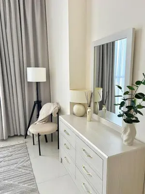 a room with a dresser with a mirror and a chair at 1BR Amazing Burj And Dubai View in Dubai