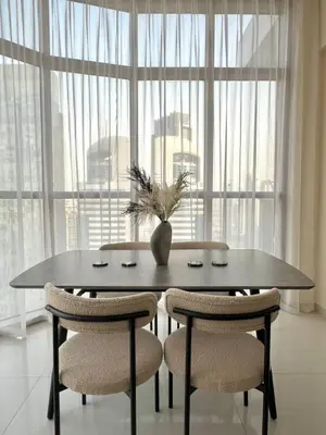 a dining room table with chairs and a vase on it at 1BR Amazing Burj And Dubai View in Dubai