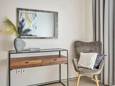 a mirror and a chair in a living room at Amazing 1BR Address Beach Resort With Private Beach in Dubai