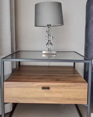 a glass table with a lamp on top of a wooden drawer at Amazing 1BR Address Beach Resort With Private Beach in Dubai