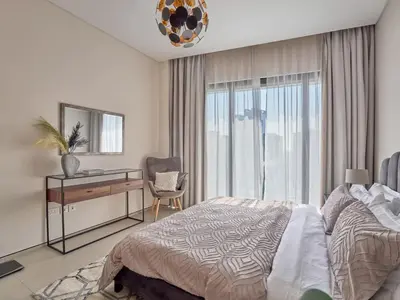 a bedroom with a bed and a desk and a window at Amazing 1BR Address Beach Resort With Private Beach in Dubai