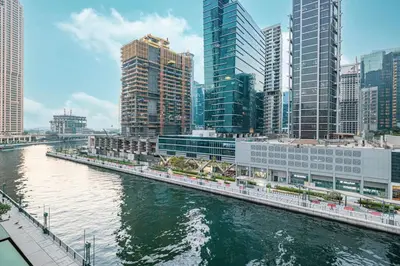 a river in a city with tall buildings at StayMada - Peninsula Exclusive Canal Front Retreat in Dubai